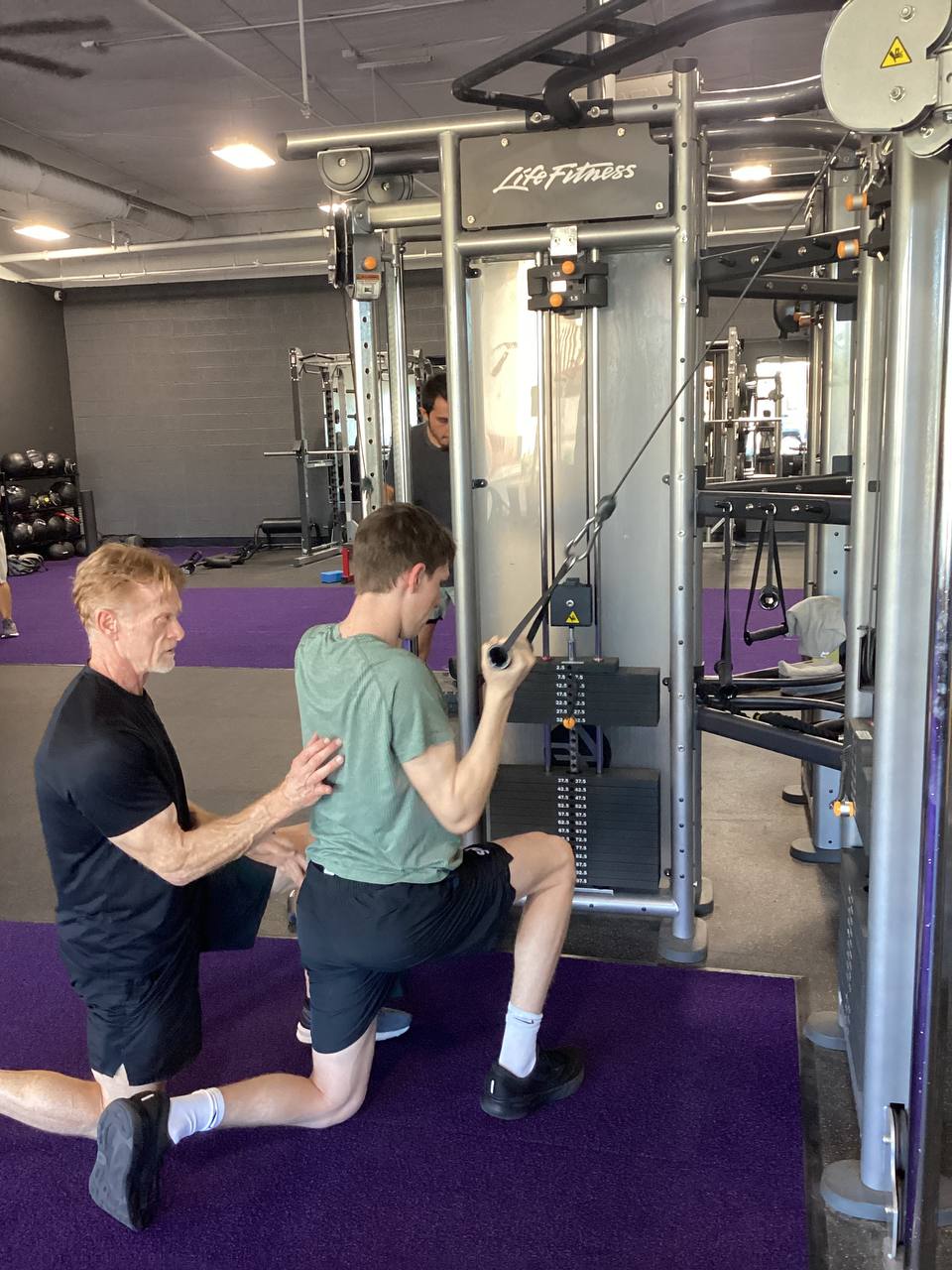 Robert coaching an athlete on the cable machine at Altis Gym, Phoenix