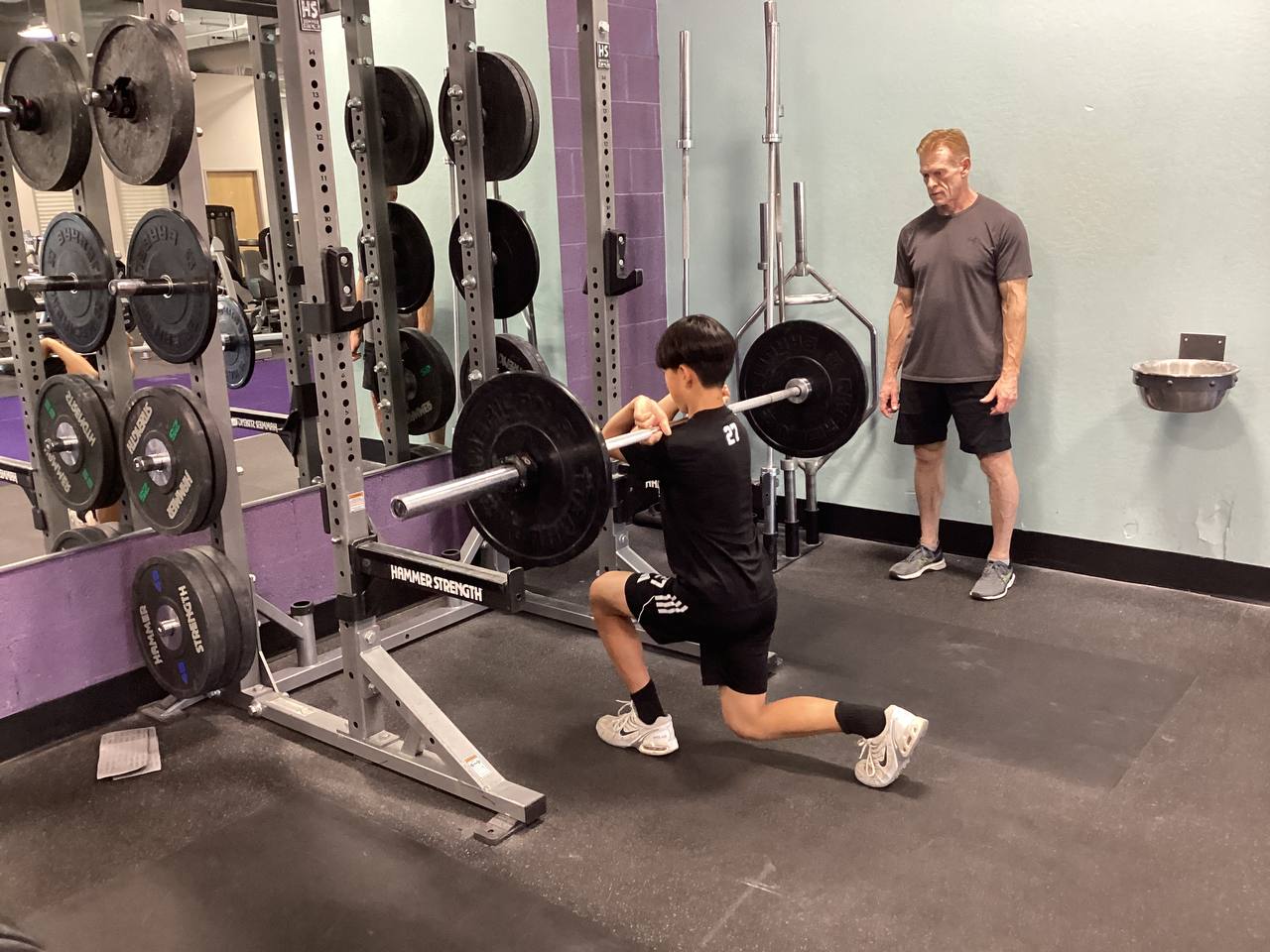 Robert observing and coaching an athlete's squat stance